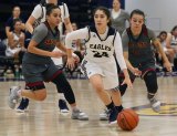 West Hills Lemoore's Monica Lopez drives between a pair of Sacramento City College defenders in Friday's WHC Tournament opener in the Golden Eagle Arena.